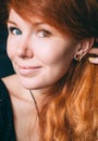 Vertical portrait of a beautiful red-haired curly girl with make-up and jewelry Royalty Free Stock Photo