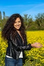 Vertical portrait of a beautiful young woman smiling looking at camera with yellow flower petals in her hand Royalty Free Stock Photo