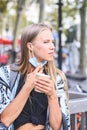 Vertical portrait of a blonde female model removing mask to drink coffee and looking to the right Royalty Free Stock Photo