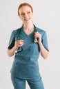 Vertical portrait of cheerful young female doctor in medical uniform with stethoscope around neck looking away. Royalty Free Stock Photo