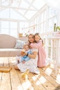 Vertical portrait of cute young mom and two adorable daughters in dress playing with little yellow ducklings in summer Royalty Free Stock Photo