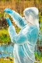 Vertical portrait of an environmentalist in protective clothing during work - lake water