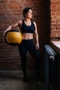 Vertical portrait of fitness young athletic woman with strong beautiful body in black sportswear posing with heavy Royalty Free Stock Photo