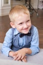 Vertical portrait of a five-year-old blonde boy in a shirt, vest and bow tie Royalty Free Stock Photo