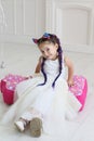 Vertical portrait of a funny five year old girl in a white studio Royalty Free Stock Photo