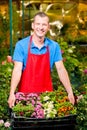 Vertical portrait of a gardener with a box of flowers
