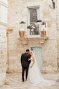 Vertical portrait of glad, cheerful romantic married couple, wedding. Overdressed, embracing in historical Italy town