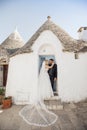 Vertical portrait glad loving romantic married couple, blond woman in white dress and black-haired man in tuxedo, Italy