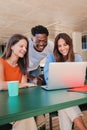 Vertical portrait of a group of multiracial happy teenage students using laptop, working on university homework project Royalty Free Stock Photo