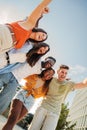 Vertical portrait of a Group of smiling multiracial teenagers having fun outdoors. Cherful young people laughing