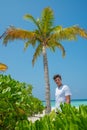 Vertical portrait of handsome man wearing white t-shirt on the tropical beach at the island luxury resort Royalty Free Stock Photo