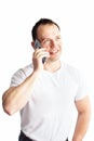 Vertical portrait of handsome self confident caucasian man in white t-shirt talking on mobile phone on white background. Royalty Free Stock Photo