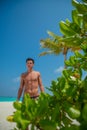 Vertical portrait of handsome sexy muscled man at tropical beach island luxury resort Royalty Free Stock Photo