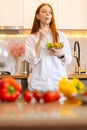 Vertical portrait of happy attractive young redhead woman eating fresh vegetarian salad enjoying fresh tasty vegetables Royalty Free Stock Photo