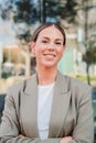 Vertical portrait of happy business woman standing at office building workplace with successful expression. Young Royalty Free Stock Photo