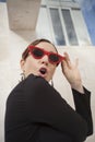 Vertical portrait of happy and cheerful mature woman outdoor, wearing retro red sunglasses with exclamation grimace. Royalty Free Stock Photo