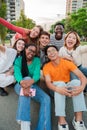 Vertical portrait of happy friends laughing. Big group of young adult real people smiling and having fun outdoors at Royalty Free Stock Photo