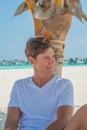 Vertical portrait of happy man relaxing on the beach at the tropical island luxury resort Royalty Free Stock Photo