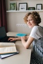Vertical portrait of happy smiling little school girl using laptop looking at camera, doing online homework with teacher Royalty Free Stock Photo