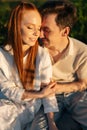 Vertical portrait of happy smiling young couple in love with closed eyes sitting embracing enjoying their time together Royalty Free Stock Photo