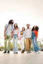Vertical portrait of happy young adult friends having fun, laughing, walking and talking together. Group of carefree and Royalty Free Stock Photo