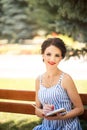 Vertical portrait of happy young brunette woman with red lipstick studying with notebook and pen in park. Business woman planning Royalty Free Stock Photo