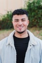 Vertical portrait of happy young man smiling and looking at camera. Front view of male teenager standing outdoors at Royalty Free Stock Photo