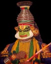 Vertical portrait of a Kathakali Hindu temple character before the black background