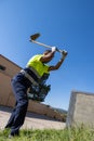 Vertical portrait of latin worker dressed in work clothes digging the earth with a sickle