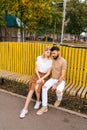 Vertical portrait of loving young couple resting in city park sitting embracing with closed eyes on bench in summer Royalty Free Stock Photo