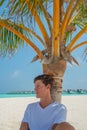 Vertical portrait of man relaxing on the beach at the tropical island luxury resort Royalty Free Stock Photo