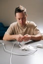Vertical portrait of man working with electronic components, stripping insulation from cable repairing, assembling Royalty Free Stock Photo