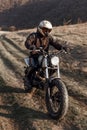 Vertical portrait of a motorcyclist equipped with helmet and protective clothing, who drives a motorcycle, at sunset. Royalty Free Stock Photo