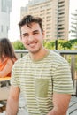 Vertical portrait of a positive and smiling young male student looking at camera sitting outside at the University Royalty Free Stock Photo