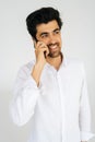 Vertical portrait of positive young man in shirt talking mobile phone, having conversation on smartphone smiling looking Royalty Free Stock Photo