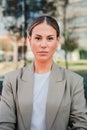 Vertical portrait of powerful business woman looking serious at camera standing at workplace. Elegant office secretary