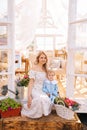 Vertical portrait of pretty blonde young female mother in dress sitting on doorstep of summer gazebo house with adorable Royalty Free Stock Photo