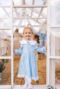 Vertical portrait of pretty 3-year-old toddler girl in beautiful dress standing posing in summer gazebo on sunny day Royalty Free Stock Photo