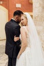 Vertical portrait of romantic married couple, after wedding, overdressed, stand outside. Italy vacation, travel abroad