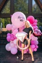 Vertical portrait of sensual blonde female in summer elegant dress posing holding various colorful festive foil helium Royalty Free Stock Photo