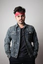 Vertical portrait of serious hipster with confident expression, wears denim jacket, isolated over white background. Royalty Free Stock Photo