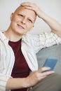 Smiling Bald Woman Using Smartphone at Home