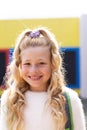 Vertical portrait of smiling cauasian elementary schoolgirl in school playground, copy space