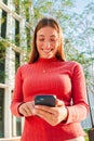 Vertical portrait of smiling real young woman using mobile phone app , texting, playing game, shopping online, ordering Royalty Free Stock Photo
