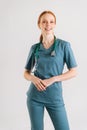 Vertical portrait of smiling young female physician in medical uniform with stethoscope around neck looking at camera, Royalty Free Stock Photo