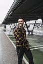 Vertical shot of a stunning smiling European male model in a stylish plaid shirt posing outdoors