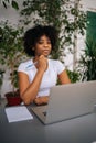 Vertical portrait of successful curly African American business woman holding pen in hand, serious looking at camera Royalty Free Stock Photo