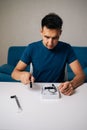 Vertical portrait of technician male assembling wi-fi module using tools at home office desk, focusing on intricate Royalty Free Stock Photo