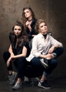 Vertical portrait of three beautiful young women posing on a chair Royalty Free Stock Photo