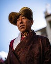 Vertical portrait of a Tibetan Buddhist village elder in traditional clothes at the Tiji Festival